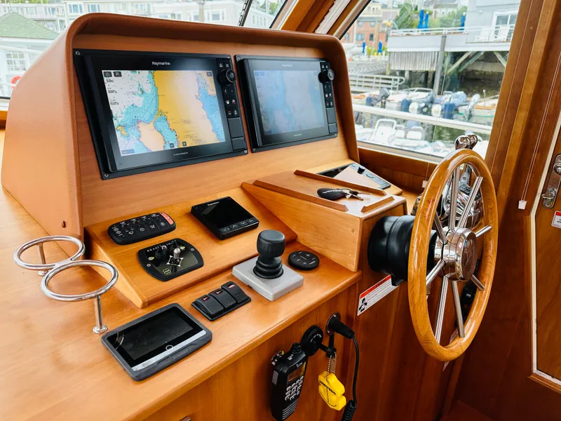 Slide: The Image of Control panel of a 2011 Sabre 40 Sedan boat with navigation screens and steering wheel. - 30