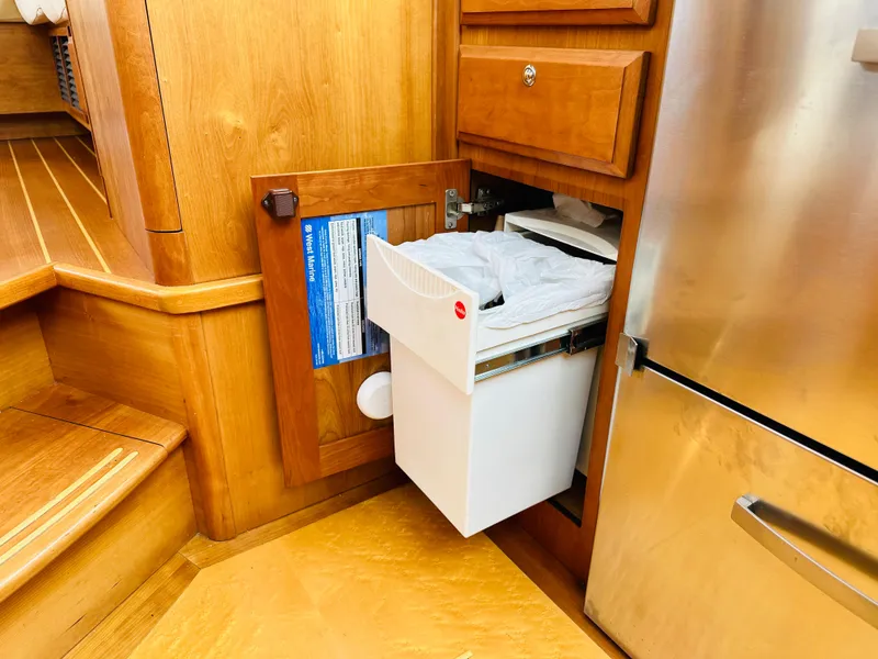 Slide: The Image of 2011 Sabre 40 Sedan interior with wooden cabinetry and pull-out trash bin. - 42