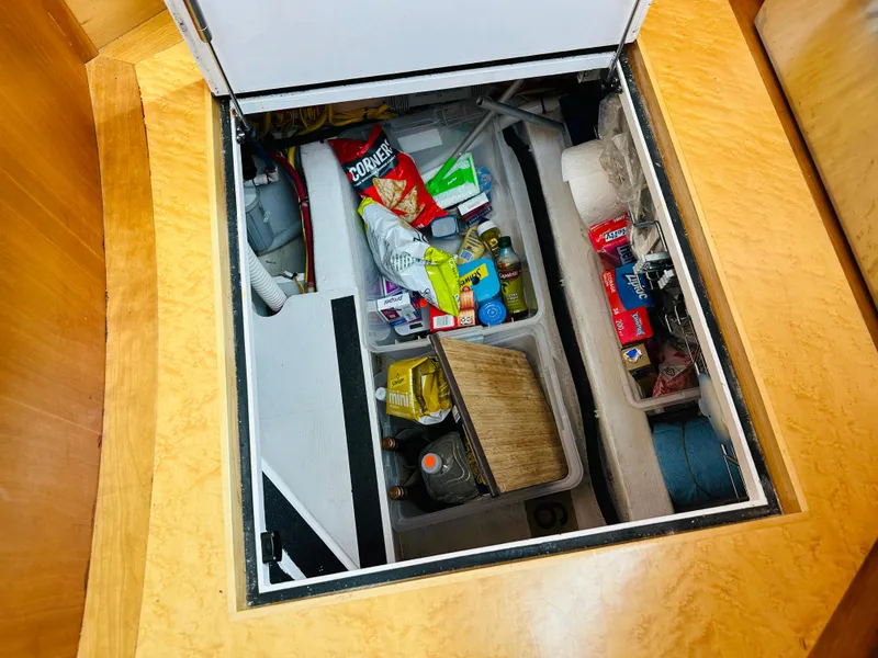 Slide: The Image of Storage compartment in a 2011 Sabre 40 Sedan, filled with various household items and supplies. - 43