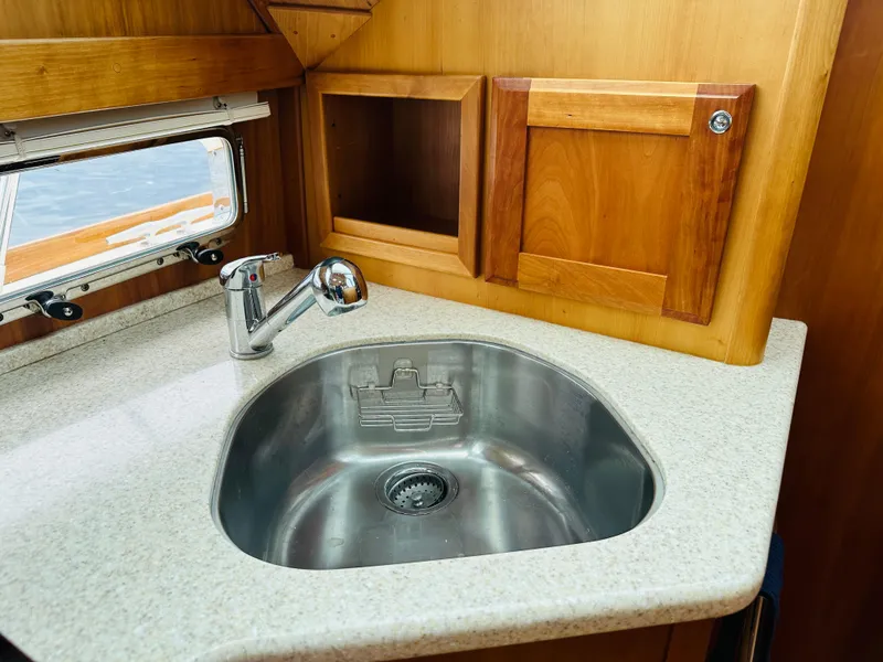 Slide: The Image of Stainless steel sink in 2011 Sabre 40 Sedan yacht kitchen with wooden cabinets. - 44