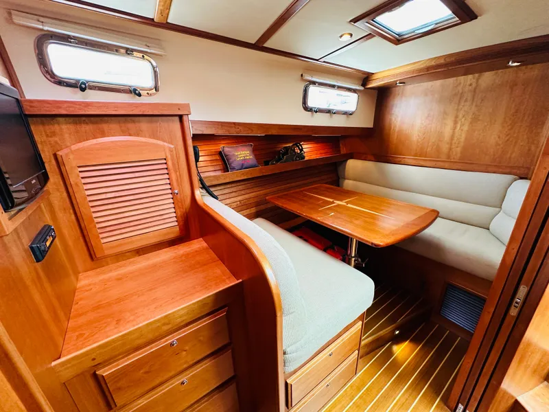 Slide: The Image of 2011 Sabre 40 Sedan interior with wooden cabinetry and cozy seating area. - 46
