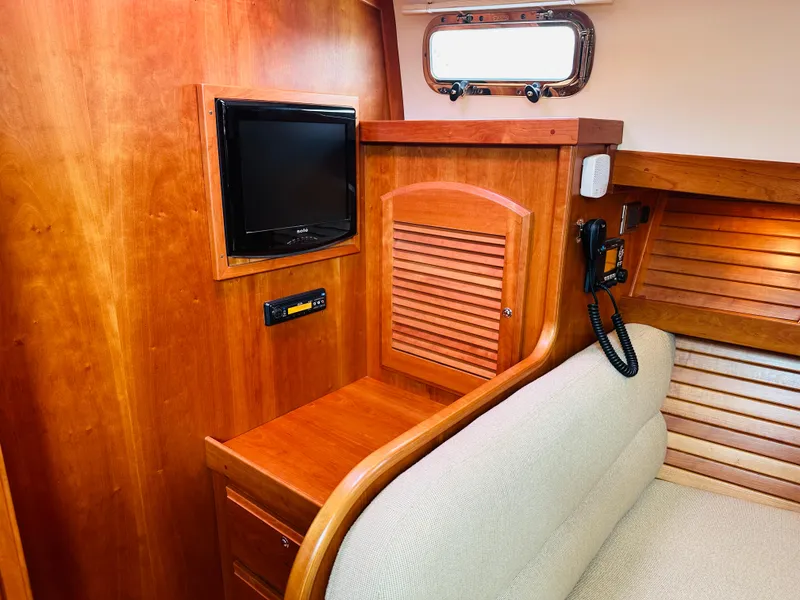 Slide: The Image of 2011 Sabre 40 Sedan interior with wood paneling, TV, and beige seating. - 49