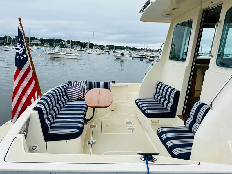 Slide: The Image of 2011 Sabre 40 Sedan yacht with striped seating, docked in a marina. - 8