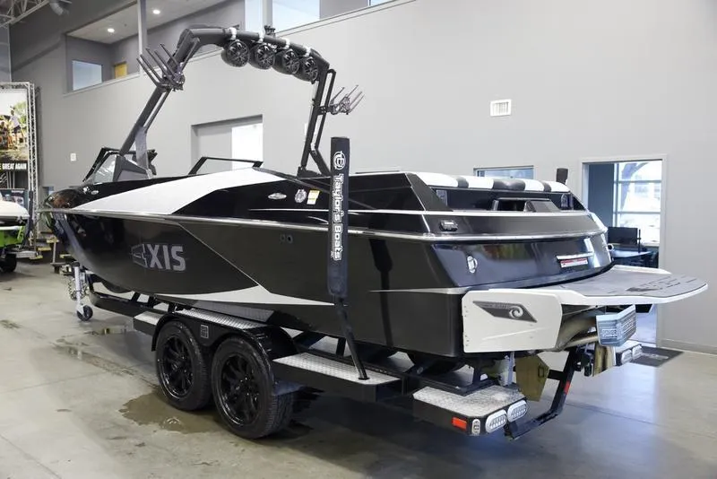 Slide: The Image of 2020 Axis A24 boat on trailer in showroom, black and white design, wakeboard tower. - 3