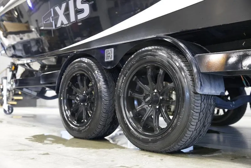 Slide: The Image of 2020 Axis A24 boat trailer with sleek black wheels in a showroom setting. - 5