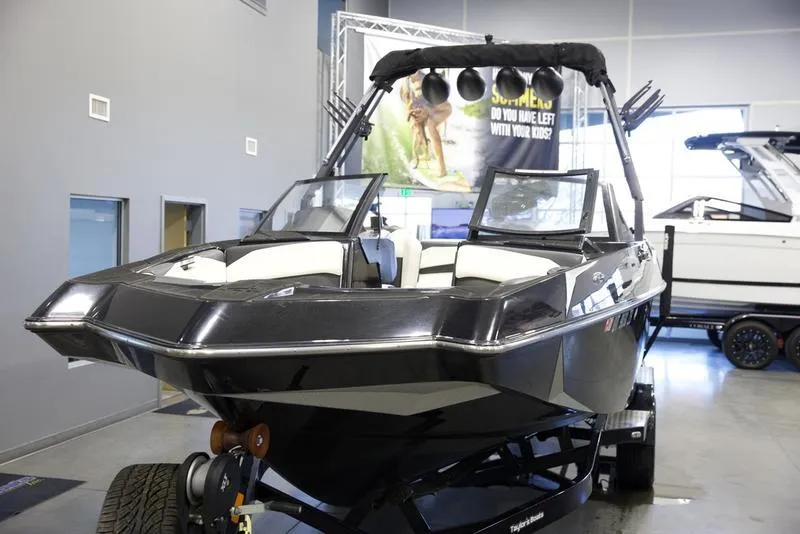 Slide: The Image of 2020 Axis A24 boat in showroom, black exterior, modern design, on trailer. - 7
