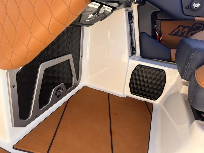 Slide: The Image of 2023 Malibu M220 interior with brown leather seats and black speaker system. - 15
