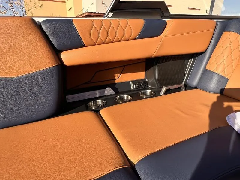 Slide: The Image of 2023 Malibu M220 interior with orange and navy leather seats, featuring cup holders. - 16