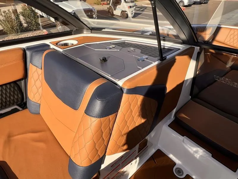 Slide: The Image of 2023 Malibu M220 boat interior with tan and navy seating, modern design. - 17