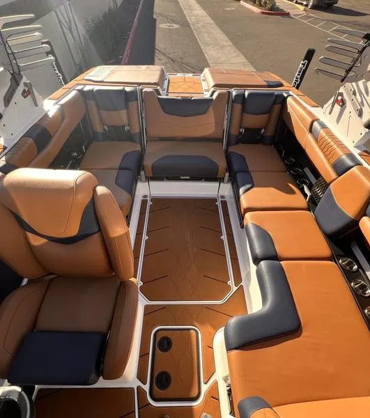Slide: The Image of 2023 Malibu M220 boat interior with luxurious tan and black seating. - 2