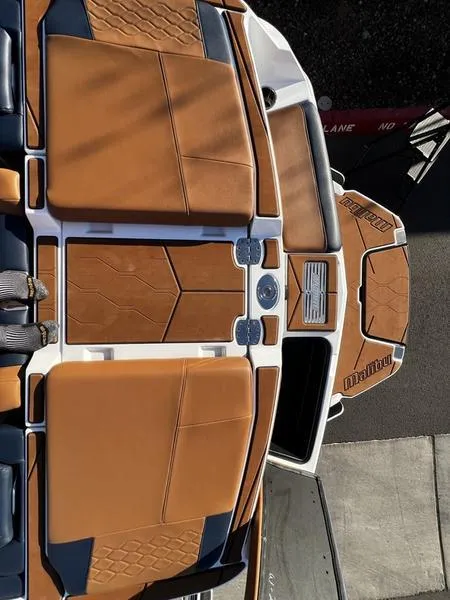 Slide: The Image of 2023 Malibu M220 boat interior with tan and blue seating, showcasing modern design. - 24