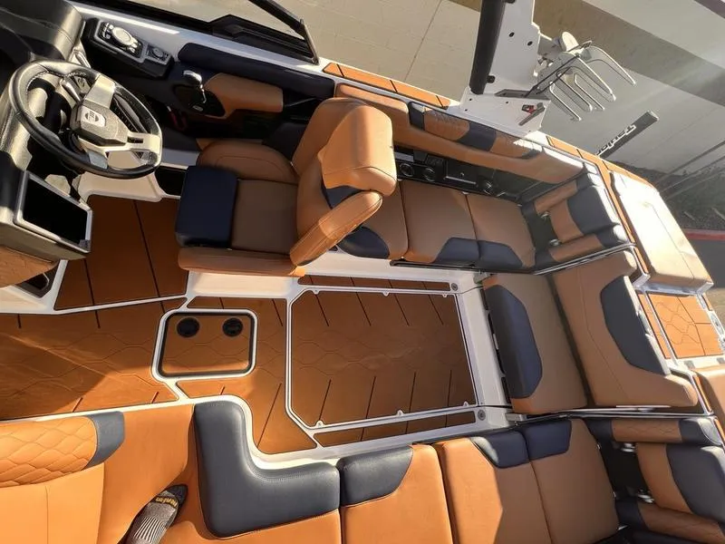 Slide: The Image of 2023 Malibu M220 boat interior with luxurious tan and navy seating, modern design. - 25