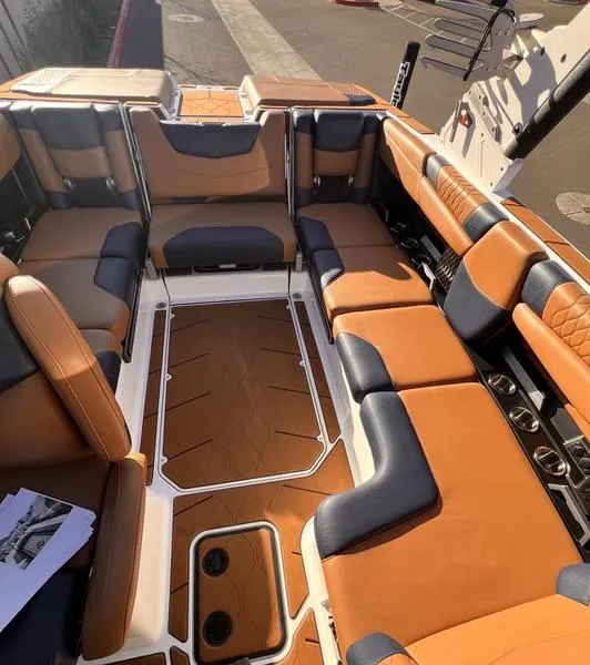 Slide: The Image of 2023 Malibu M220 boat interior with luxurious tan and black seating. - 26