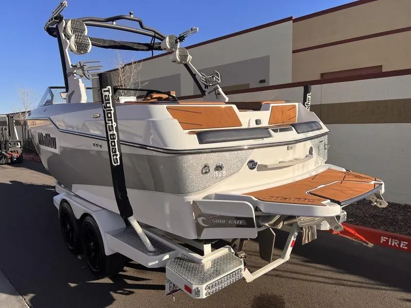 Slide: The Image of 2023 Malibu M220 boat on trailer, rear view, showcasing sleek design and features. - 3