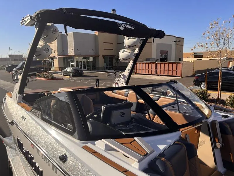Slide: The Image of 2023 Malibu M220 boat with sleek design and modern features, parked outdoors. - 6