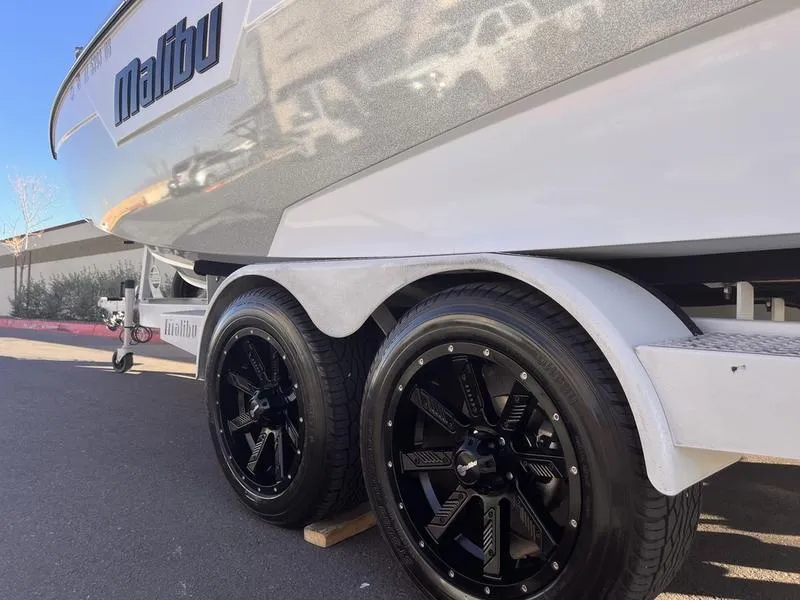 Slide: The Image of 2023 Malibu M220 boat on trailer with black alloy wheels. - 7