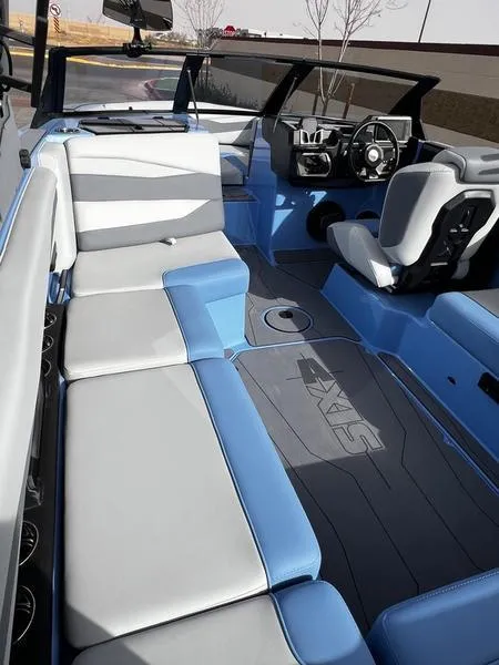 Slide: The Image of 2025 Axis A225 boat interior with blue and gray seating, modern dashboard, and spacious layout. - 15