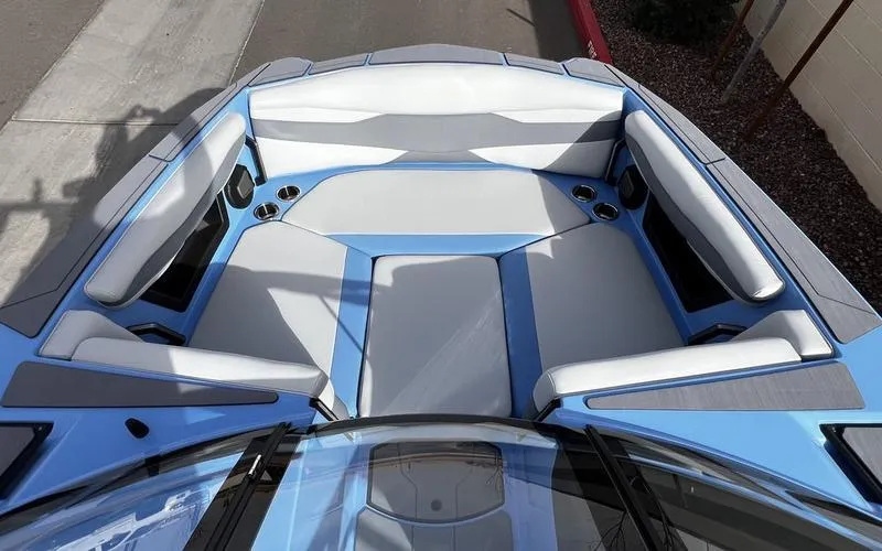 Slide: The Image of 2025 Axis A225 boat interior with blue and gray seating, cup holders, and modern design. - 22