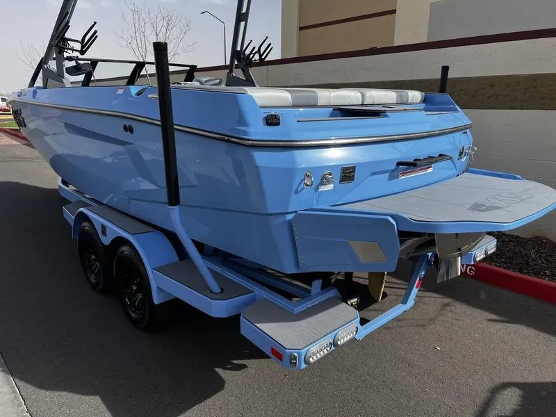 Slide: The Image of 2025 Axis A225 boat on trailer, blue exterior, parked outdoors. - 3