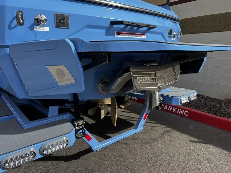 Slide: The Image of 2025 Axis A225 boat stern with propeller and Power Wedge, parked on pavement. - 4