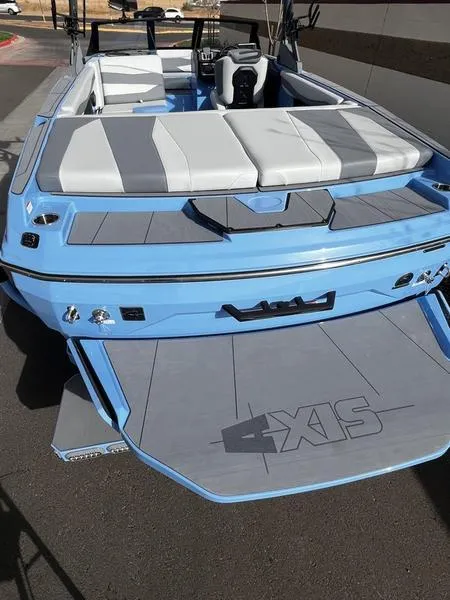 Slide: The Image of 2025 Axis A225 boat, light blue exterior, gray seating, rear view. - 8