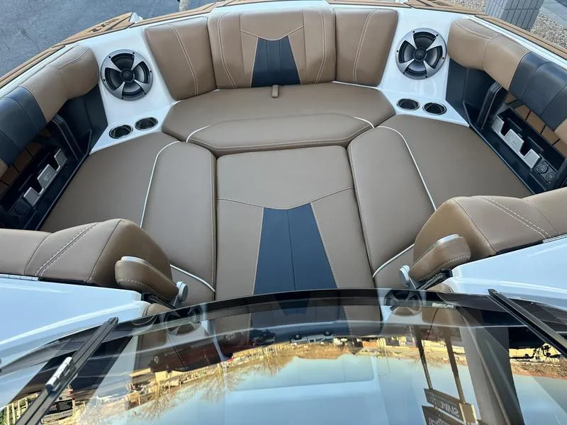 Slide: The Image of 2021 Malibu 24 MXZ boat interior with tan leather seating and built-in speakers. - 13