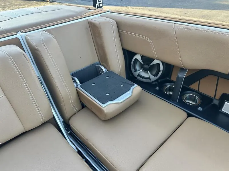 Slide: The Image of 2021 Malibu 24 MXZ boat interior with tan leather seats and built-in speakers. - 15