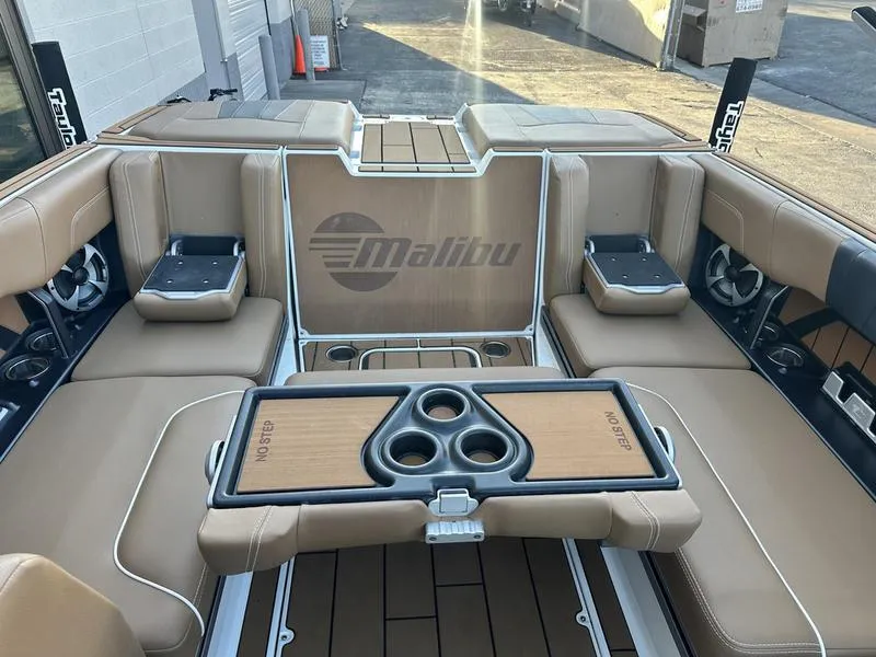 Slide: The Image of 2021 Malibu 24 MXZ boat interior with tan seating and cup holders. - 16