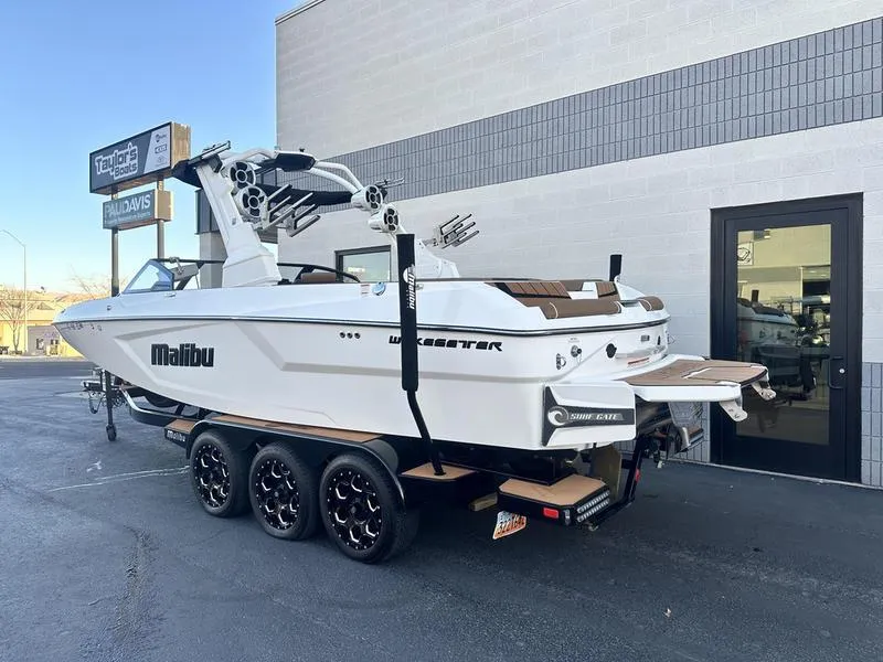 Slide: The Image of 2021 Malibu 24 MXZ boat on trailer outside dealership. - 3