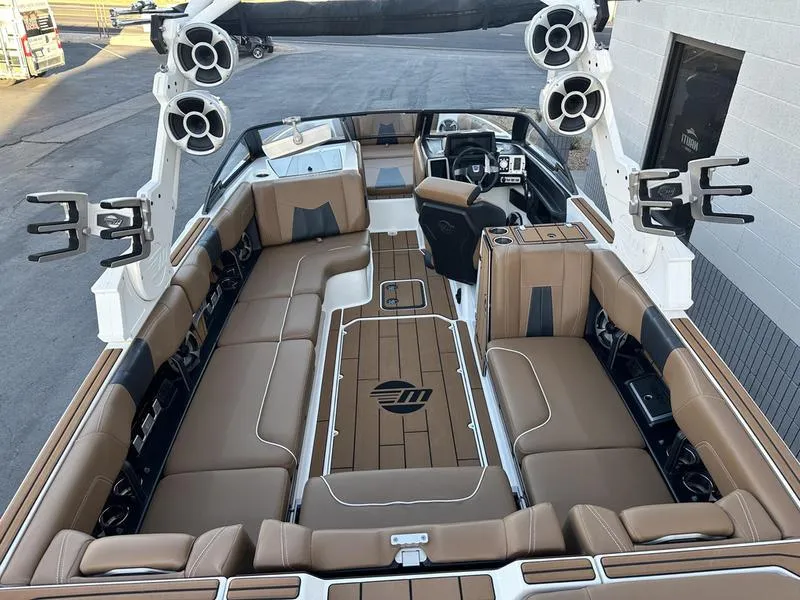 Slide: The Image of 2021 Malibu 24 MXZ boat interior with spacious seating and advanced audio system. - 8