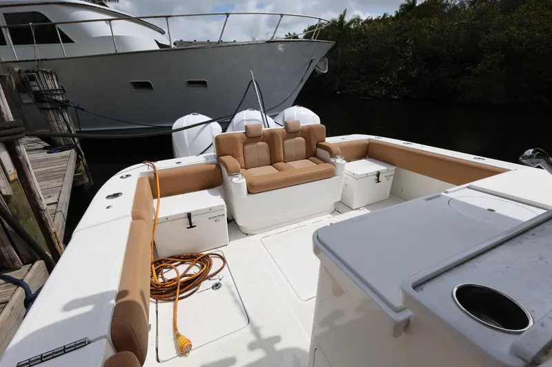 Slide: The Image of 2020 HCB Speciale boat interior with tan seating and docked yacht in background. - 22