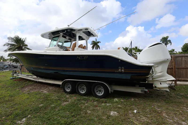 Slide: The Image of 2020 HCB Speciale boat on trailer, parked on grass with palm trees in background. - 35