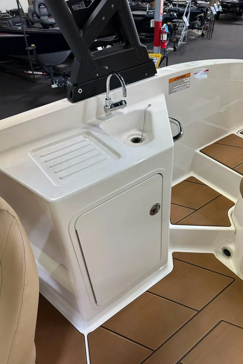 Slide: The Image of 2024 Bayliner DX 2250 boat interior with sink and storage compartment. - 13