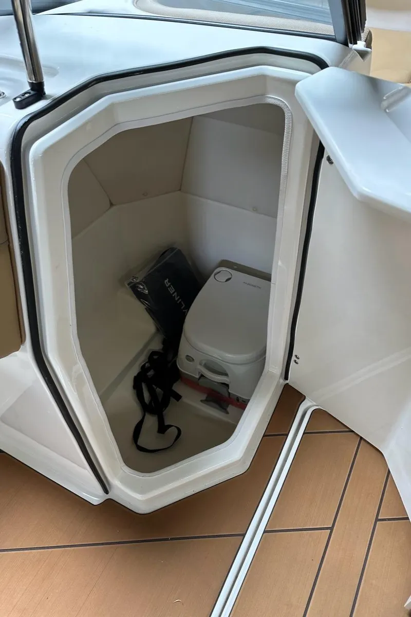 Slide: The Image of 2024 Bayliner DX 2250 boat storage compartment with portable toilet and accessories. - 14