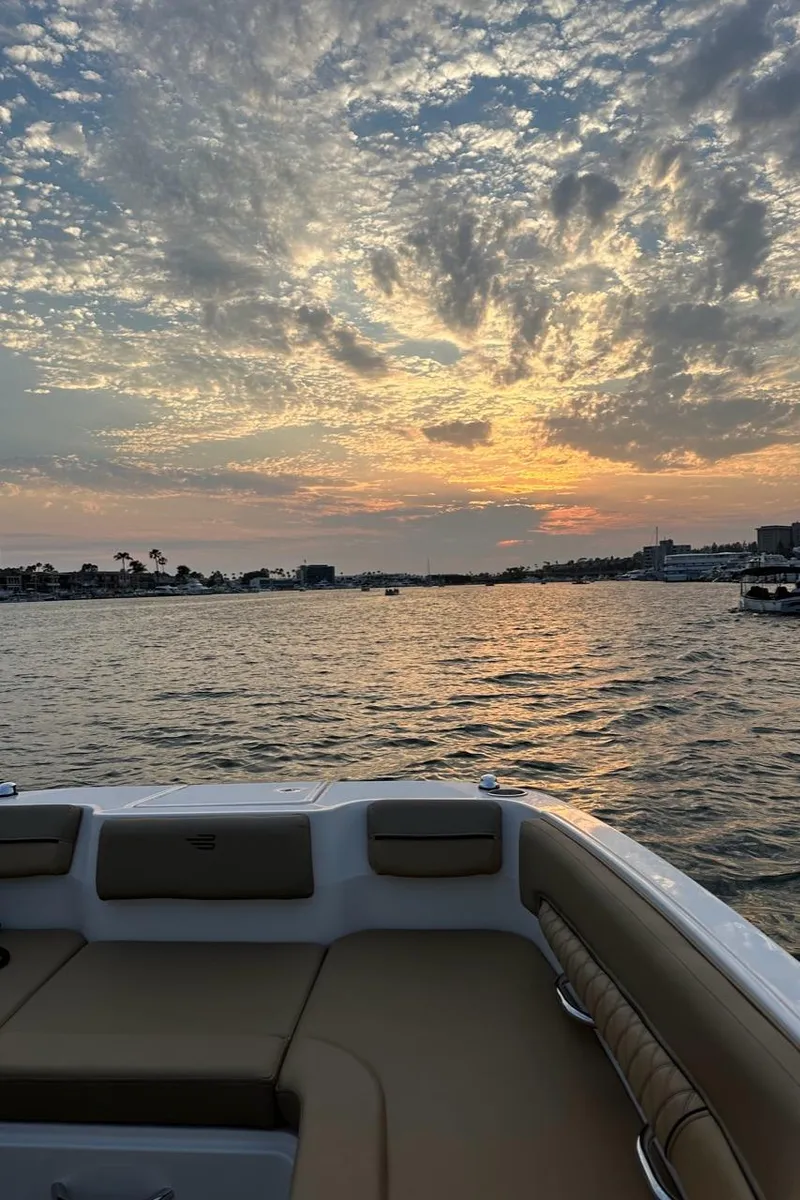 Slide: The Image of 2024 Bayliner DX 2250 boat at sunset on a tranquil lake. - 17