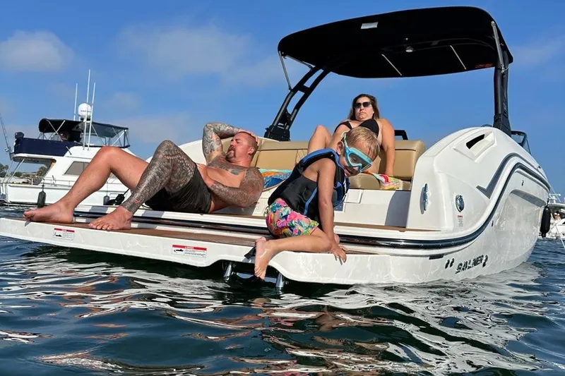 Slide: The Image of 2024 Bayliner DX 2250 boat with family relaxing on deck in sunny waters. - 3