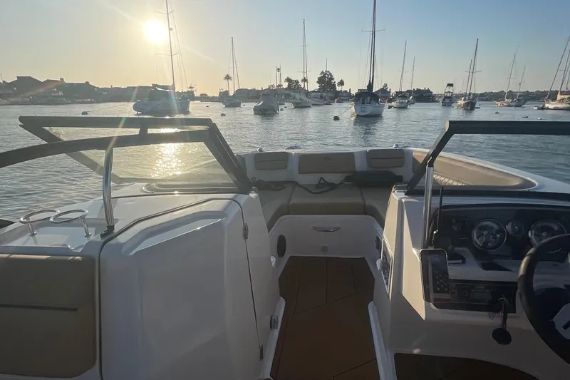 Slide: The Image of 2024 Bayliner DX 2250 boat interior with scenic marina view at sunset. - 5