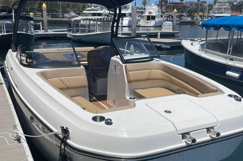 Slide: The Image of 2024 Bayliner DX 2250 boat docked, featuring spacious seating and sleek design. - 6