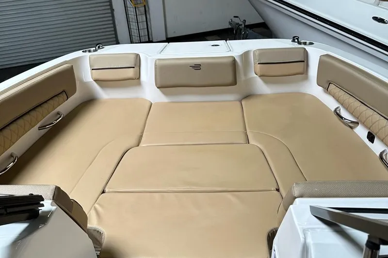 Slide: The Image of 2024 Bayliner DX 2250 boat interior with beige seating and spacious layout. - 7