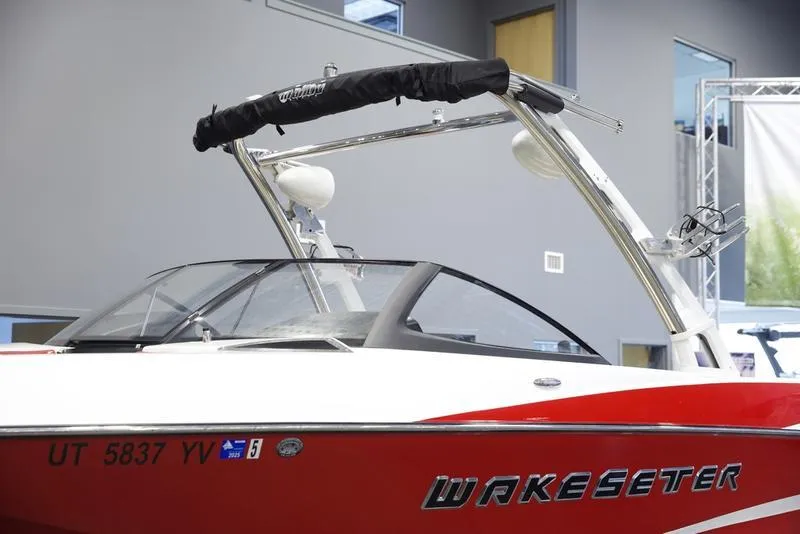 Slide: The Image of 2014 Malibu 247 LSV Wakesetter boat, red and white, with wakeboard tower. - 3