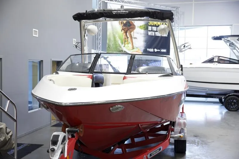 Slide: The Image of 2014 Malibu 247 LSV boat in showroom, red and white exterior, on trailer. - 4