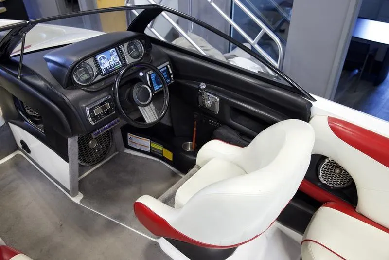 Slide: The Image of Interior of a 2014 Malibu 247 LSV boat with modern dashboard and white-red seating. - 8