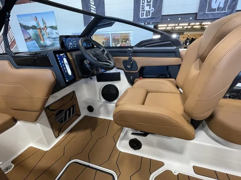 Slide: The Image of 2025 Malibu 23 MXZ boat interior with tan seats and modern dashboard. - 10