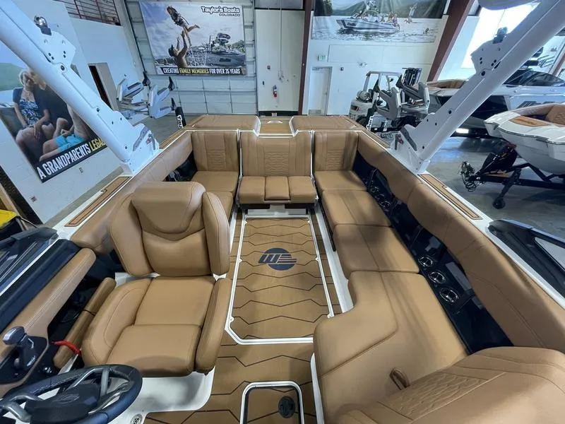 Slide: The Image of 2025 Malibu 23 MXZ boat interior with tan seating and modern design. - 12