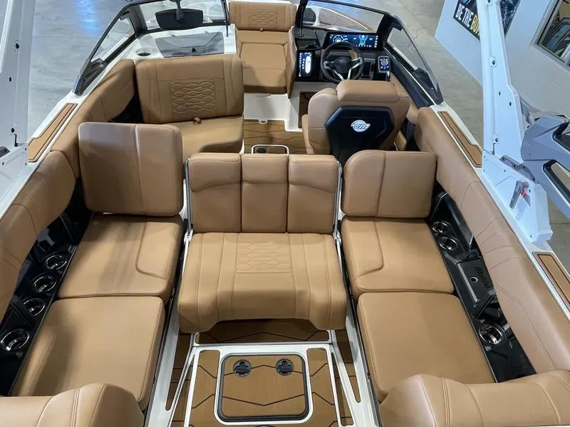 Slide: The Image of 2025 Malibu 23 MXZ boat interior with luxurious tan seating and modern dashboard. - 18
