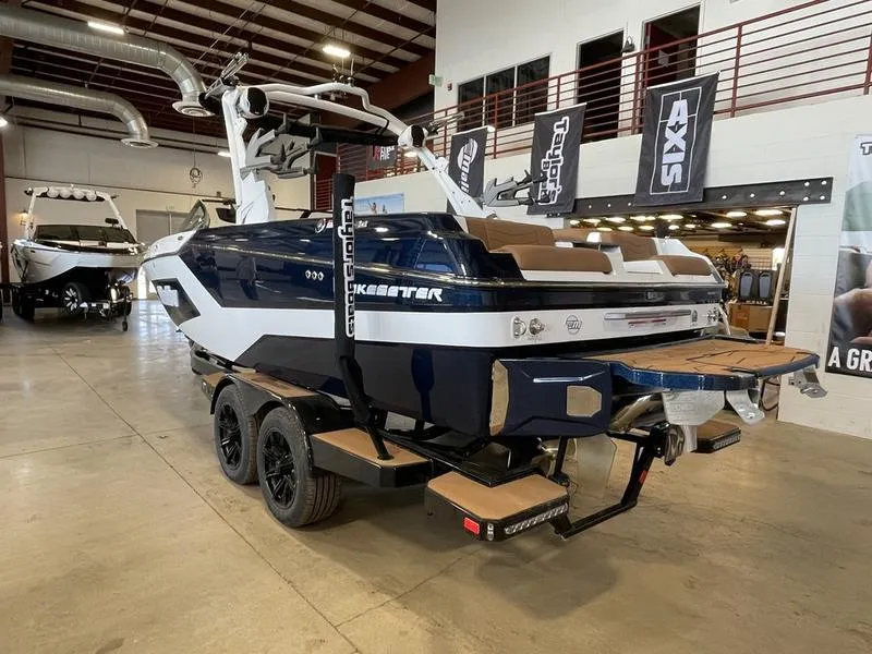 Slide: The Image of 2025 Malibu 23 MXZ boat in showroom, featuring sleek design and modern amenities. - 2