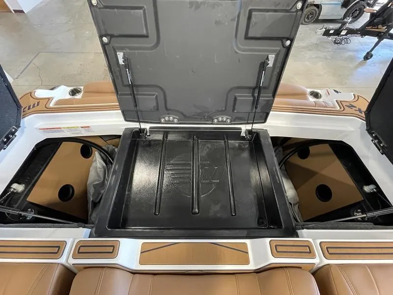 Slide: The Image of 2025 Malibu 23 MXZ boat storage compartments with open hatches, showcasing interior space. - 23