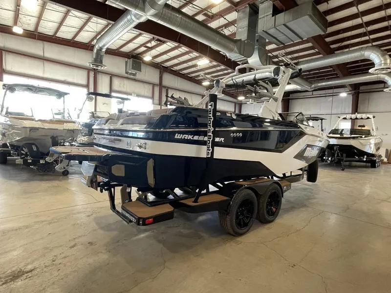 Slide: The Image of 2025 Malibu 23 MXZ boat in a showroom, featuring sleek design and modern features. - 26