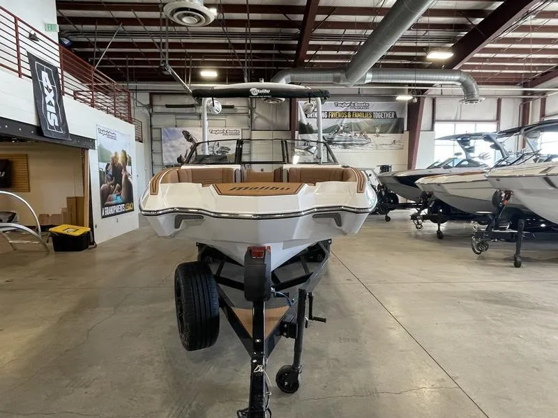 Slide: The Image of 2025 Malibu 23 MXZ boat displayed in a showroom, front view. - 3