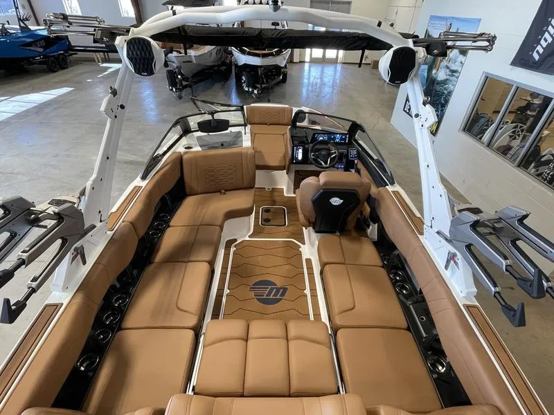 Slide: The Image of 2025 Malibu 23 MXZ boat interior with tan seating and modern dashboard. - 5